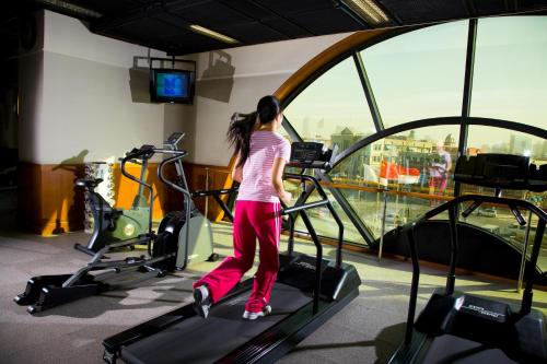a woman walking on a treadmill in a gym at Somerset Olympic Tower Tianjin in Tianjin