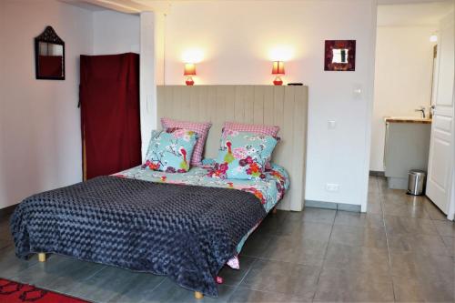 a bedroom with a bed with blue and pink pillows at Ilot du Moulin in Mordelles