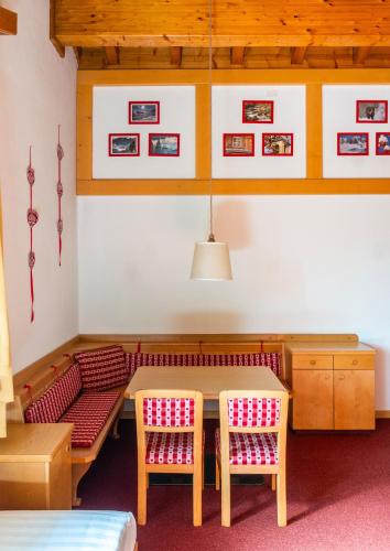 a living room with a table and two chairs at Ambiez Residencehotel in Madonna di Campiglio