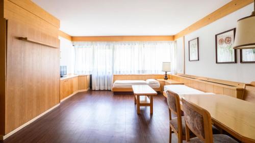a room with a table and chairs and a couch at Ambiez Residencehotel in Madonna di Campiglio