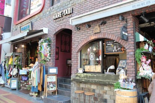 a store front of a brick building with stools at HARE-TABI SAUNA & INN Yokohama - ハレタビ - in Yokohama