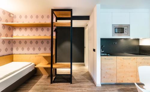 a small apartment with a bunk bed and a kitchen at Ambiez Residencehotel in Madonna di Campiglio