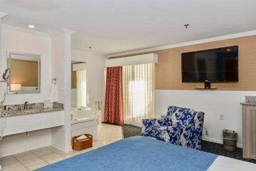 a hotel room with a bed and a tv on the wall at Avenue Inn & Spa in Rehoboth Beach