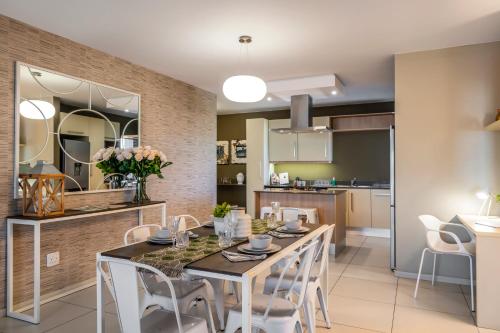 a kitchen and dining room with a table and chairs at CAG The Hub Bryanston in Johannesburg