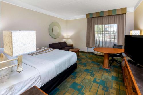 a hotel room with a bed and a flat screen tv at La Quinta by Wyndham Phoenix West Peoria in Peoria