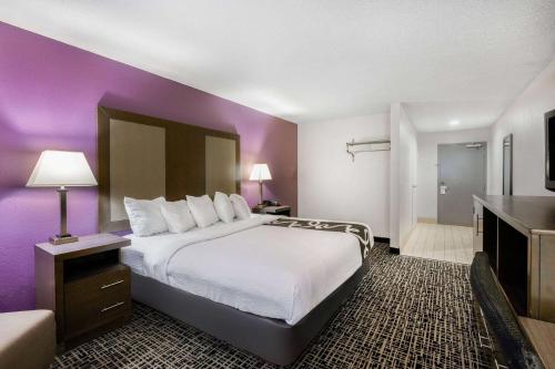a hotel room with a large bed and purple walls at La Quinta Inn by Wyndham North Myrtle Beach in Myrtle Beach
