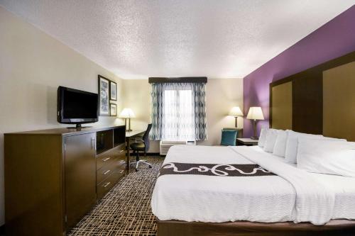 a hotel room with a bed and a flat screen tv at La Quinta Inn by Wyndham North Myrtle Beach in Myrtle Beach
