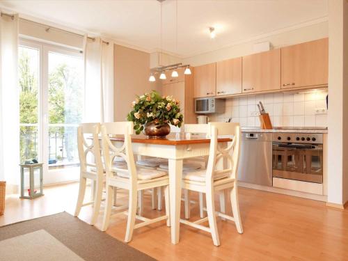 a kitchen with a wooden table with chairs and a table and a table at Ostsee Residenz Meeresblick Strandjuwel in Insel Poel