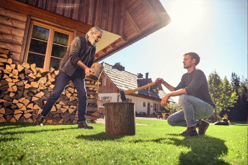 two men are playing a game in front of a cabin at Alpine Homestead in Goreljek