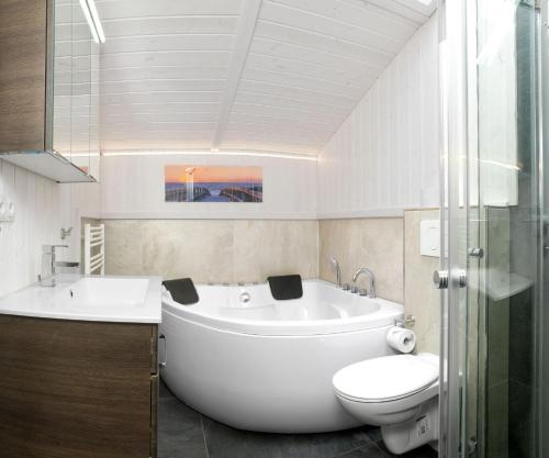 uma casa de banho com uma banheira, um WC e um lavatório. em Dänische Ferienhäuser am Salzhaff Haus Strandhafer em Gollwitz