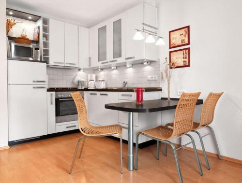 a kitchen with a table and chairs in it at Landhaus Residenz Kirchsee Ostseetraum in Insel Poel