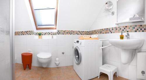 a bathroom with a washing machine and a sink at Einhusen Kornkammer in Einhusen