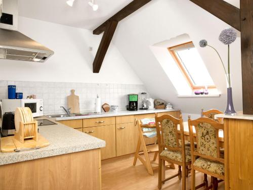 an attic kitchen with wooden cabinets and a window at FeWo Windrose in Gollwitz