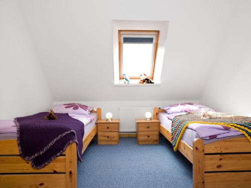 2 camas individuales en una habitación con ventana en FeWo Windrose, en Gollwitz