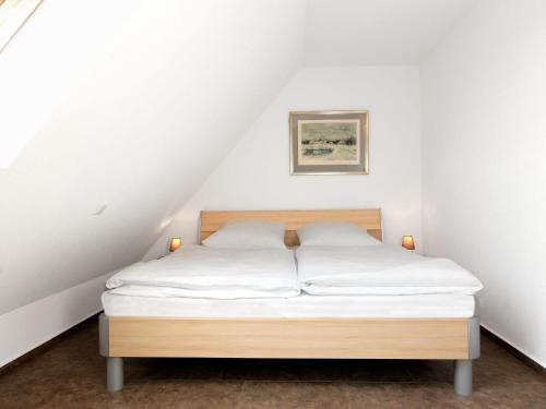 Bett in einem Zimmer mit weißen Wänden in der Unterkunft Lütt Kajüt - FIP Park in Insel Poel