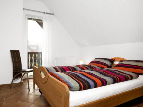 a bedroom with a bed with a striped blanket on it at Haus Meernixe in Kaltenhof