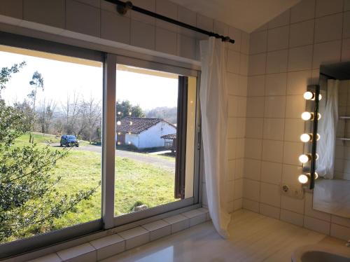 a bathroom with a window with a view of a yard at Casa Oriental in Cereceda