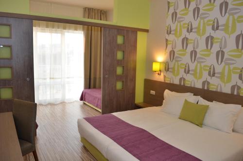 een hotelkamer met een bed en een raam bij Aqua Nevis Hotel & Aqua Park - All Inclusive in Sunny Beach