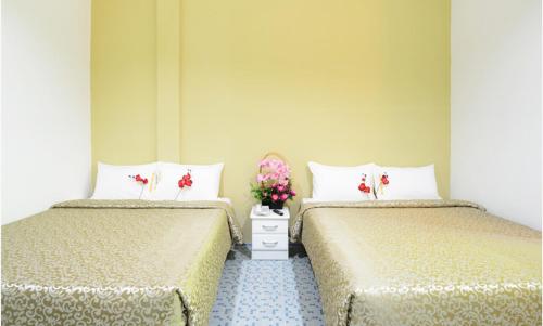 two beds sitting next to each other in a room at Grand Inn - Penang Road in George Town