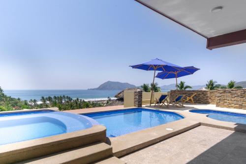 a swimming pool with a view of the ocean at Grand View Suites in Manzanillo