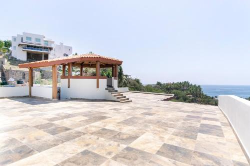 a gazebo on the side of a building with the ocean at Grand View Suites in Manzanillo