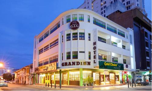 a large white building on a city street at night at Grand Inn - Penang Road in George Town