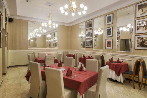 a restaurant with tables and chairs and a chandelier at Bristol Kralovska Vila in Karlovy Vary