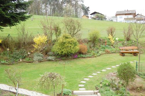 a garden with a bench in the middle of it at Gästehaus Fidelis in Grafenwiesen