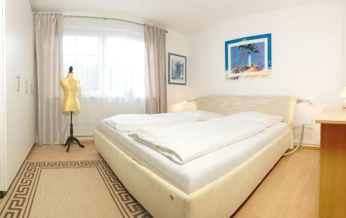 uma cama branca num quarto com uma cómoda e uma janela em Appartements Am Reiterhof Strandträumer em Insel Poel