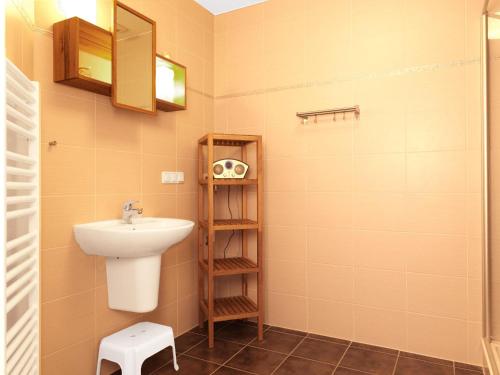 ein Badezimmer mit einem Waschbecken, einem WC und einem Regal in der Unterkunft Reihenhäuser Timmendorf Strand Haus Strandmuschel in Insel Poel