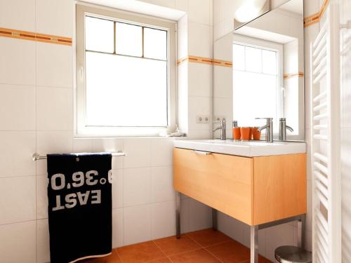 eine kleine Küche mit einem Waschbecken und einem Fenster in der Unterkunft Doppelhäuser Timmendorf Strand Haus Taun Lüchttorm in Insel Poel