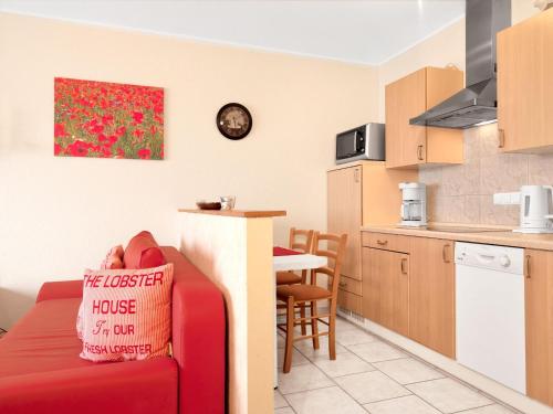 ein Wohnzimmer mit einer roten Couch in der Küche in der Unterkunft Kleine Hafenkoje in Insel Poel
