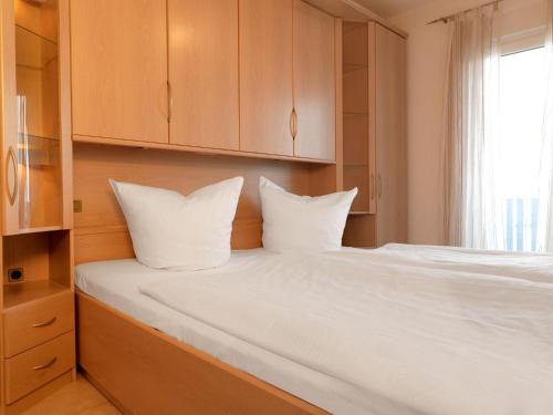 Schlafzimmer mit einem Bett mit weißer Bettwäsche und einem Fenster in der Unterkunft Kleine Hafenkoje in Insel Poel