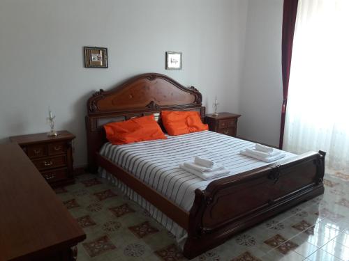1 dormitorio con 1 cama grande con almohadas de color naranja en Casa Carletta en San Cataldo