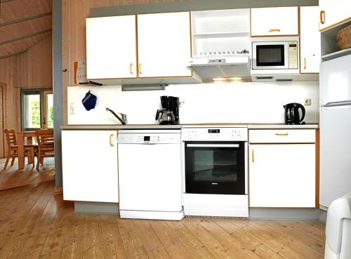 een keuken met witte werkbladen en witte apparaten bij Dänisches Ferienhaus in Kaltenhof