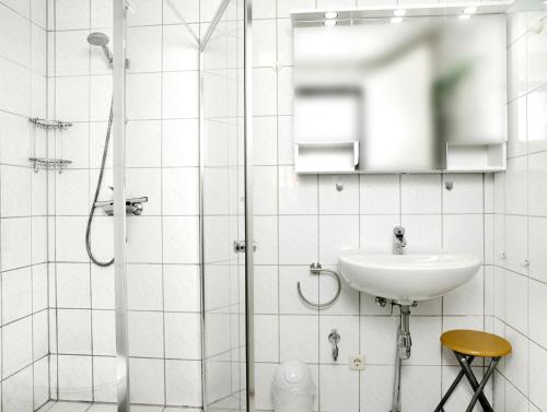 une salle de bain blanche avec un lavabo et une douche dans l'établissement Buchenweg Whg.24, Sommerfeld, EG li, à Poel