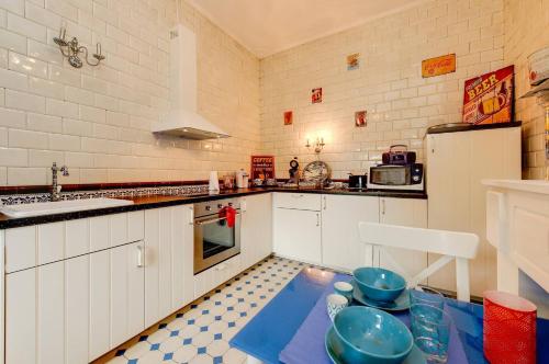 a kitchen with white cabinets and blue bowls on a table at B&B Villa Belle Epoque in Durbuy