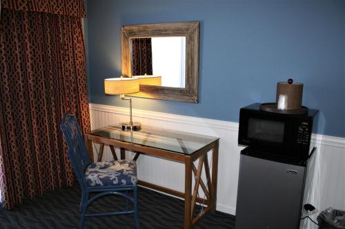 a room with a desk with a microwave and a television at Avenue Inn & Spa in Rehoboth Beach
