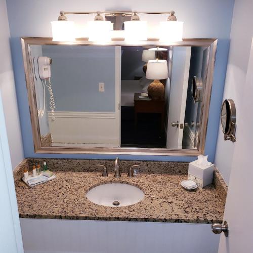 a bathroom with a sink and a mirror at Avenue Inn & Spa in Rehoboth Beach