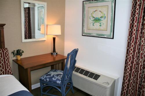 a room with a desk and a bed and a chair at Avenue Inn & Spa in Rehoboth Beach