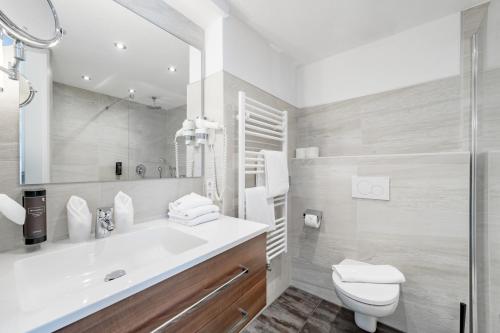 a bathroom with a sink and a toilet and a shower at Hotel Zum Gourmet in Seefeld in Tirol