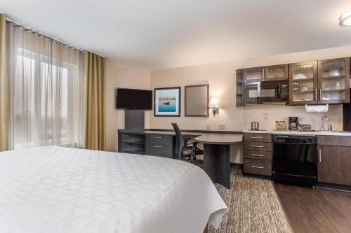 a hotel room with a bed and a kitchen at Candlewood Suites Bensalem - Philadelphia Area by IHG in Bensalem