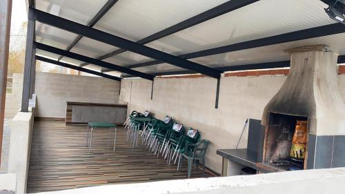 a patio with chairs and a table and a fireplace at Paraiso del Alberche in Navaluenga