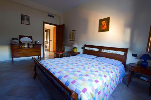 a bedroom with a bed with a colorful comforter at ACQUARIO DEI FRALLE in Oristano