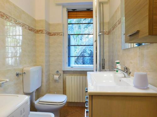 a bathroom with a toilet and a sink and a window at Fantastico appartamento in centro, Levanto in Levanto
