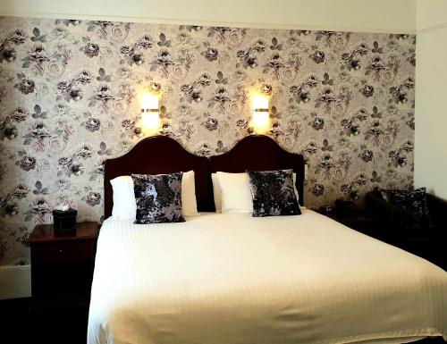 a bedroom with a large bed with two pillows at Best Western Annesley House Hotel in Norwich