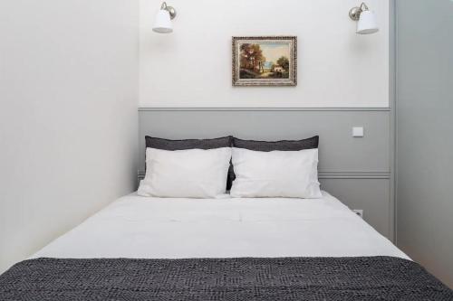 um quarto com uma cama branca e almofadas brancas em AmaOporto - St. Ildefonso no Porto