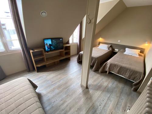a hotel room with two beds and a television at Angleterre Hotel in Paris