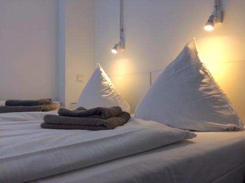 2 almohadas blancas encima de la cama en BNB near Brandenburg Gate - Rooms & Apartments, en Berlín