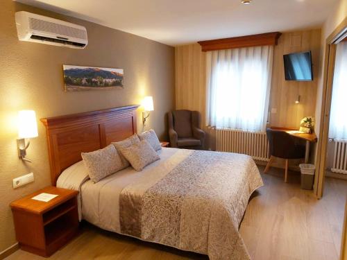 una camera d'albergo con letto e sedia di Hotel-Restaurante La Quadra a Maçanet de Cabrenys
